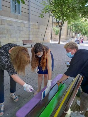 Voluntaris de Colors de Ponent pintant un banc a la rambla d'Aragó.