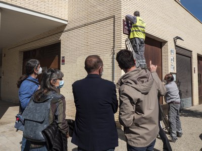 Un treballador de la brigada municipal col·loca la placa del carrer Elena Pàmies..