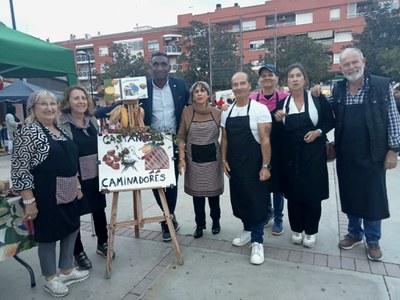 El regidor del barri, Jackson Quiñónez, amb els i les integrants de la parada "Castanyeres Caminadores".