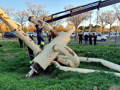 Els operaris carreguen les peces de l'escultura a un camió ploma per traslladar-la.