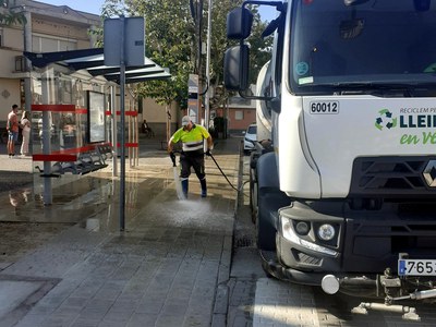 Un operari d'Ilnet neteja amb aigua a pressió al carrer a Llívia.