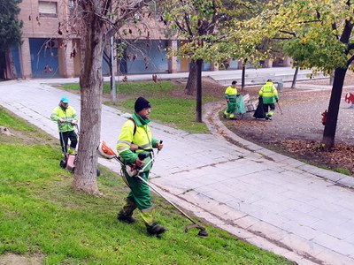 Operaris treballant en la neteja del parc de Joc de la Bola.