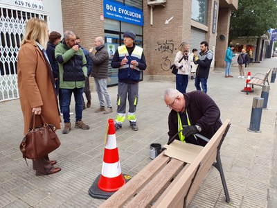 Un operari treballa en la renovació d'un banc a Bisbe Irurita.